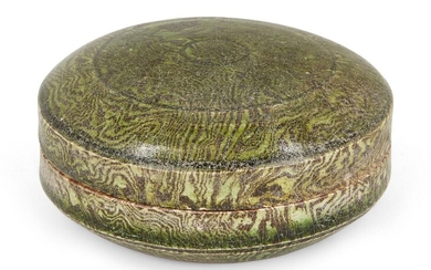 A Chinese marbled pottery green-glazed circular box and cover, Tang dynasty, covered in a translucent green glaze that stops neatly around the edge of the base, 9cm diameter. Note: Marbling, or jiao tai ('mixed clay'), was a popular decoration...