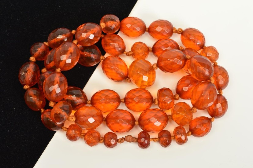 A FACETED AMBER BEAD NECKLACE, designed as oval and spherica...