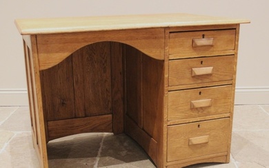 A George V honey oak kneehole desk, with an arched kneehole ...