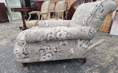 A HOWARD TYPE ARMCHAIR BY WILLIAM BIRCH UPHOLSTERED IN GREY FLORAL MATERIAL, ONE MAHOGANY BACK LEG