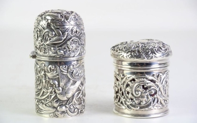 A Late Victorian heavily chased hallmarked silver container featuring birds (H11.5cm), t/w a silver jar with ruby glass liner (H8cm)