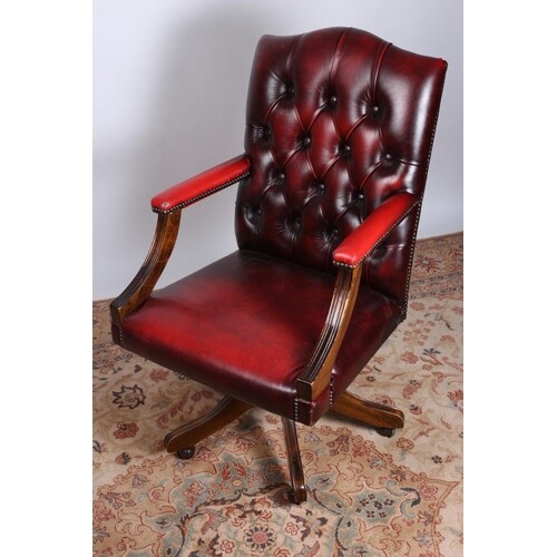 A RED HIDE UPHOLSTERED AND MAHOGANY SWIVEL LIBRARY CHAIR wit...