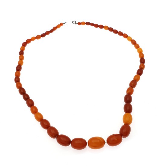 A graduated amber necklace set with numerous oval polished amber beads and a clasp of silver. Pearl measurements app. 9×7–24 17.5 mm. L. 74 cm.