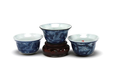 A group of blue and white porcelain teacup painted with dragons writhing amid clouds on a blue ground