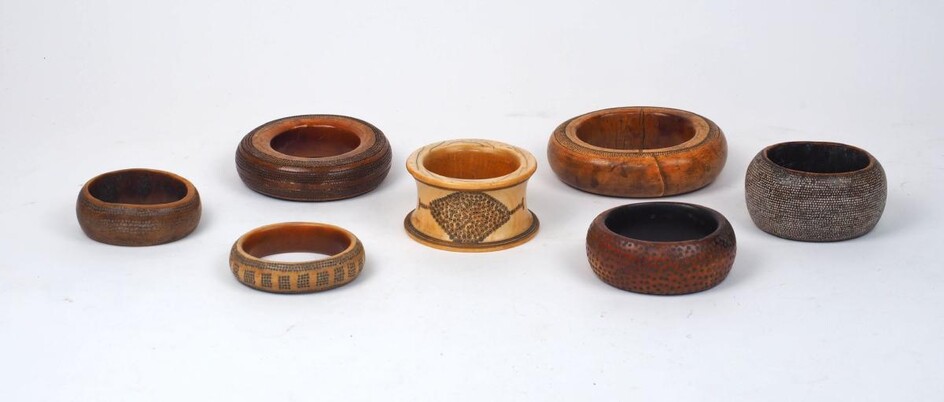 A group of large mixed African ivory bangles, 19th century, of varying patinas and sizes, some with additional decoration and various traditional repairs, one has additional metal terminals, bound with leather, one with additional later added...