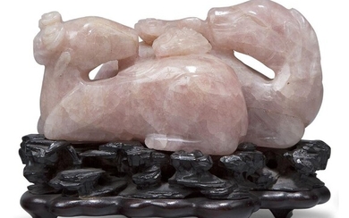 A large Chinese carved rose quartz celestial rams group, 18th/19th century, each carved in recumbent pose, one clutching a lingzhi sprig in its mouth, 12cm long, on fitted hardwood stand Provenance: From the collection of an important Greek...