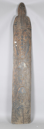 A large Papua New Guinea carved wooden panel, decorated with a vertical band of masks, height 244cm