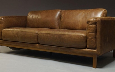 A modern leather three seater sofa, of recent manufacture, with...