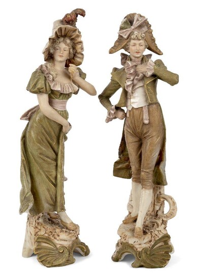 A pair of Royal Dux figures, 19th century, depicting a gallant and a young lady in green, beige and brown colour way, standing atop tree trunk bases with leaf and scrollwork decoration, triangle mark and press numbers 491 and 492 to underside, 36cm...
