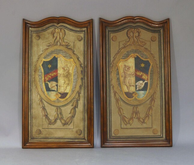 A pair of painted armorial panels, 20th century, on wood, each with a shield centred in a medallion with husk swags, in shaped mahogany frames, 132 x 72cm (2)