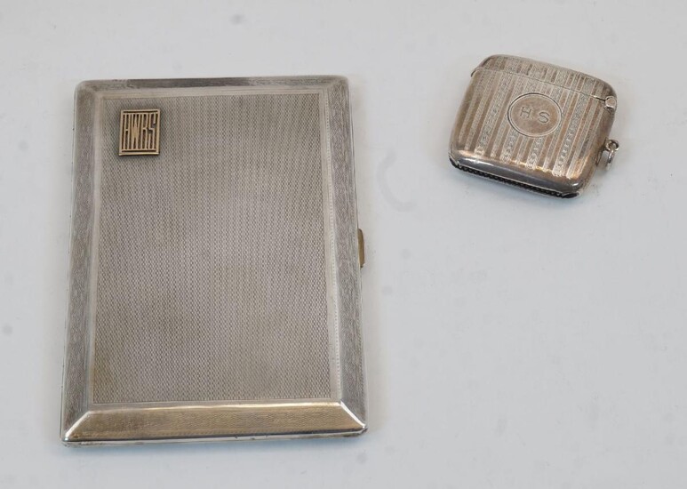 A silver rectangular cigarette case, Chester, 1929, Asprey & Co Ltd., with engine turned decoration within a Greek key border, applied white metal initials to lid, having gilded interior, 12.5cm wide, 8.6cm deep, together with a silver vesta case...