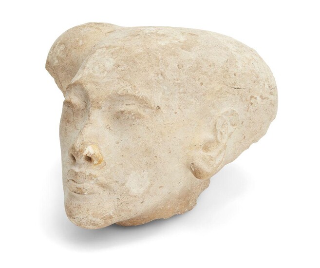 A sizeable Egyptian style limestone head of an Amarna style princess, with elongated skull with the top of the sidelock remaining and defined features, Not Ancient, 28.2cm long, 23cm wide, 17cm high Provenance: Formerly in the private collection of...