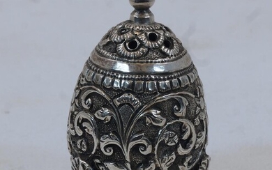 A white metal salt shaker, Kutch India, on three raised feel, deeply engraved with flower heads and vine, opening to base, 6.7cm. high