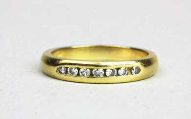 An 18ct yellow gold (tested) diamond set half eternity ring, (N).