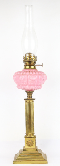 An antique brass oil lamp with pink moulded glass shade,...