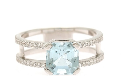 An aquamarine and diamond ring set with an emerald-cut aquamarine flanked by numerous brilliant-cut diamonds, mounted in 18k white gold. Size 51.
