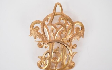 Brooch in yellow gold with monogram decoration.