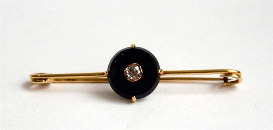Gold (750) brooch set with an onyx disc...