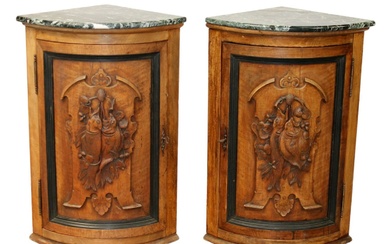 Pair of French corner cabinets with relief trophy carvings and...