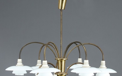 Poul Henningsen: “PH-Bombardement”. Nine branched chandelier with brass frame, sockethouses of white bakelite, 2/1 shades of opal glass. Diam. 68 cm.