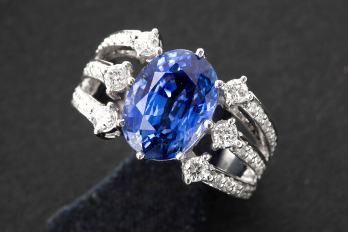 Ring in white gold (18 carat) with a corpus with three bands, set with brilliant, and with a central oval cut tanzanite with beautiful color - in total : ca 5 carat sapphire and ca 1 carat white (G/H) quality brilliant (Vs/Si) || Ring in white gold...