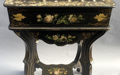 Table travailleuse en bois laqué noir incrusté de nacre et polychromé figurant un décor floral....