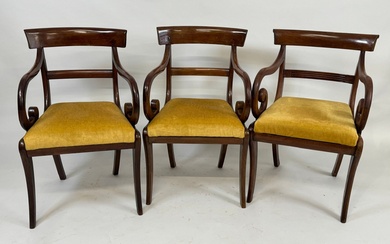 Trois fauteuils en acajou mouluré, les accotoirs à enroulement, l'assise en velours jaune. Style Restauration....