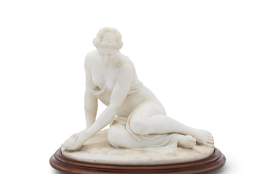 A carved marble figure of a girl sitting on a beach