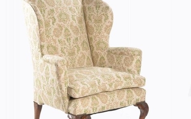 A George II walnut and upholstered wing armchair