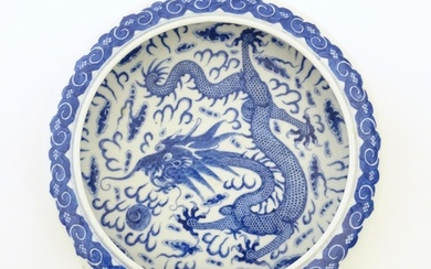 A Chinese blue and white bowl / dish decorated with a dragon...