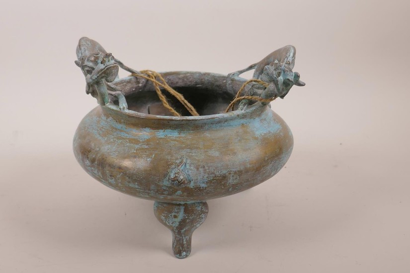 A Chinese bronze censer on tripod supports with two dragon h...