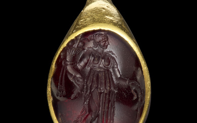 A GREEK GOLD AND GARNET FINGER RING WITH TYCHE LAT...