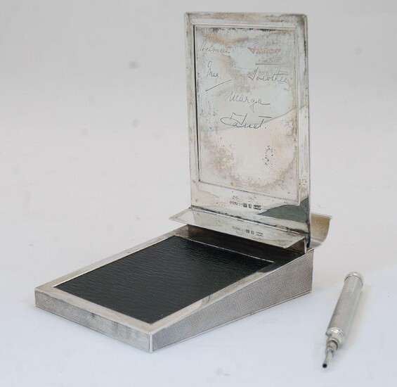 A George V desk note pad holder, London, circa 1930s, Asprey & Co Ltd, the engine-turned case with hinged lid with six facsimile signatures to underside, revealing leather writing slope, 3.5cm high, 8cm wide, 12.5cm deep, with associated engine...