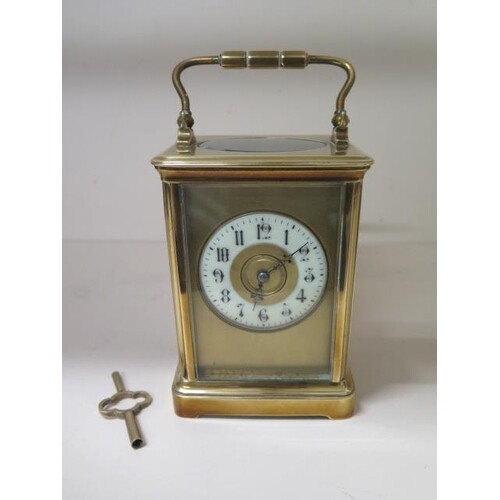 A brass carriage clock striking on a gong, 18cm tall with ha...
