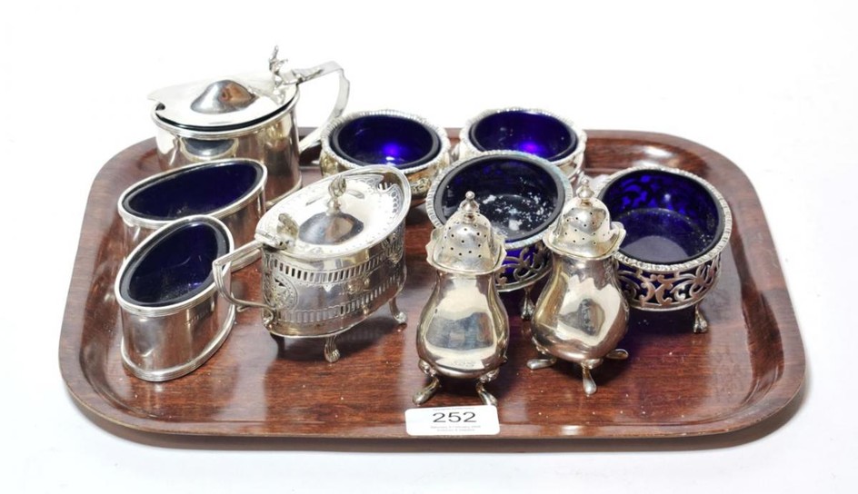 A collection of silver condiment items, comprising: a plain oval...