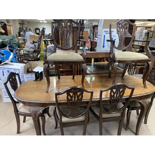 A glazed top mahogany dining table with carved legs and a se...