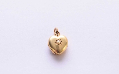 A heart shaped yellow metal pearl set locket