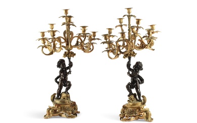 A large pair of French gilt and patinated bronze eleven light candelabra, 19th century and later