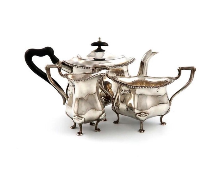 A three-piece Edwardian silver tea set, by The Goldsmiths and Silversmiths Company, London 1907 and 1909, shaped oval form, gadroon borders, scroll handles, on four paw feet, length handle to spout 24cm, approx. weight 22.5oz. (3)