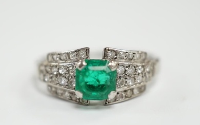 A white metal and octagonal cut emerald set dress ring, with...