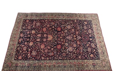 AN ANTIQUE KASHAN CARPET woven in colours with all-over flo...