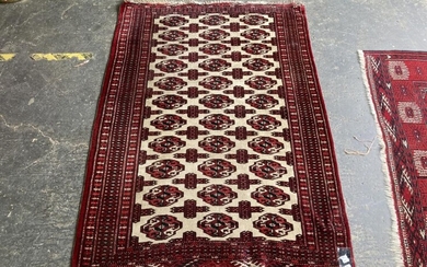 Afghan Turkoman Wool Carpet, with three columns of octagons & cruciform spacers, in cream and red tones (150 x 105)