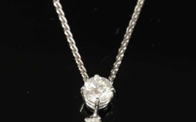 An 18ct white gold emerald and diamond pendant