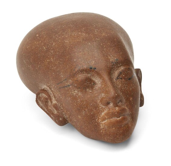 An Egyptian style brown quartzite head of an Amarna style princess, with elongated skull and defined features with traces of black outline on the eyes, Not Ancient, 16.4cm long, 7.2cm high Provenance: Formerly in the private collection of Werner...