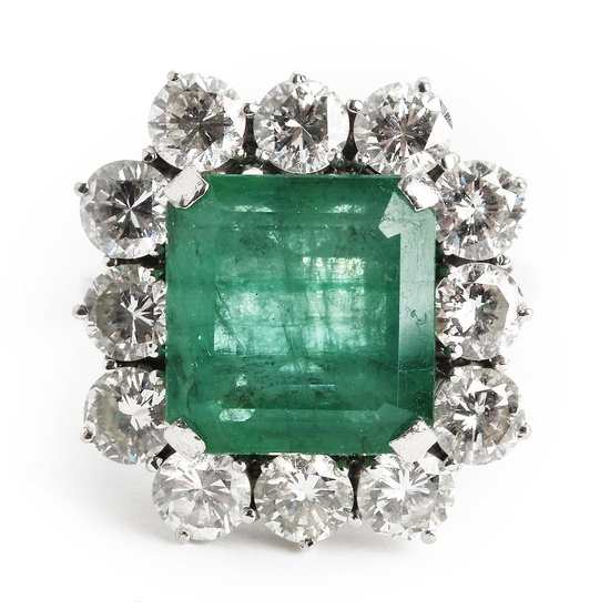 An emerald and diamond ring with an emerald-cut emerald weighing...