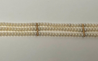 BRACELET composé de trois rangs de perles de culture blanches alternées de maillons en or...