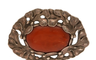 Evald Nielsen: An amber brooch set with an amber cabochon, mounted in silver. 7.5×5 cm.