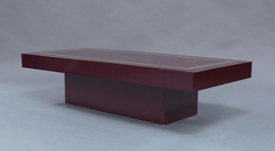 Manner of Willy Rizzo, a lacquered low table, c.1970, the rectangular top inset with gilt metal trim, on conforming plinth base, 31.5cm high, 130cm wide, 60cm deep
