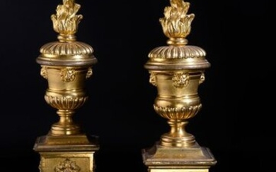 Pair of chiseled and gilt bronze andirons, resting on four raven feet, the square base with grained leaves on a amati background surmounted by a fire pot with lion mufles and gadroon friezes.