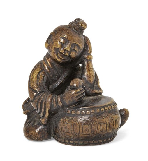 Property of a Gentleman (lots 36-85) A Chinese bronze scroll weight, Ming dynasty, 17th century modelled as a seated boy playing a large drum, 5cm high